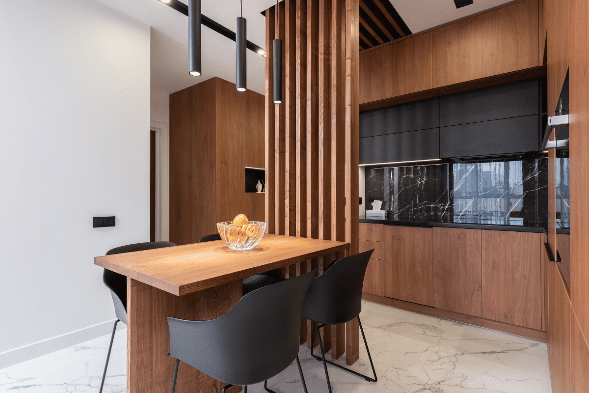 Interior of contemporary kitchen with wooden table and furniture in modern apartment 